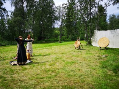 Två personer som skjuter båge mot måltavla.